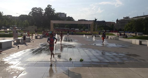 Brno, Moravské náměstí. Pondělí 11. 7., 18 hod. Na rozpáleném náměstí hledaly děti osvěžení u fontánek.