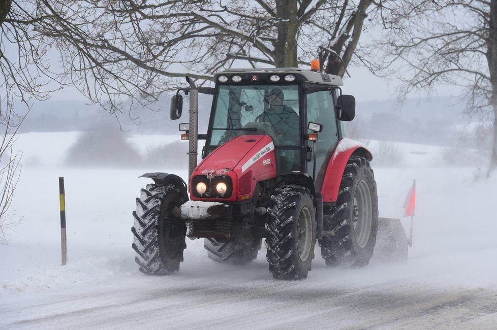 Traktor s radlicí za silného větru odhrnuje sníh ze silnice 30. listopadu 2021 u Protivanova na Prostějovsku.