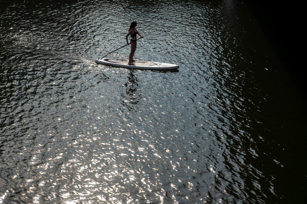 Vysoké teploty v těchto dnech lákají k osvěžení. Snímek z 3. srpna 2018 je z centra Hradce Králové, kde lidé plují po Labi na paddleboardech, koupou se v řece nebo se opalují na náplavkách.