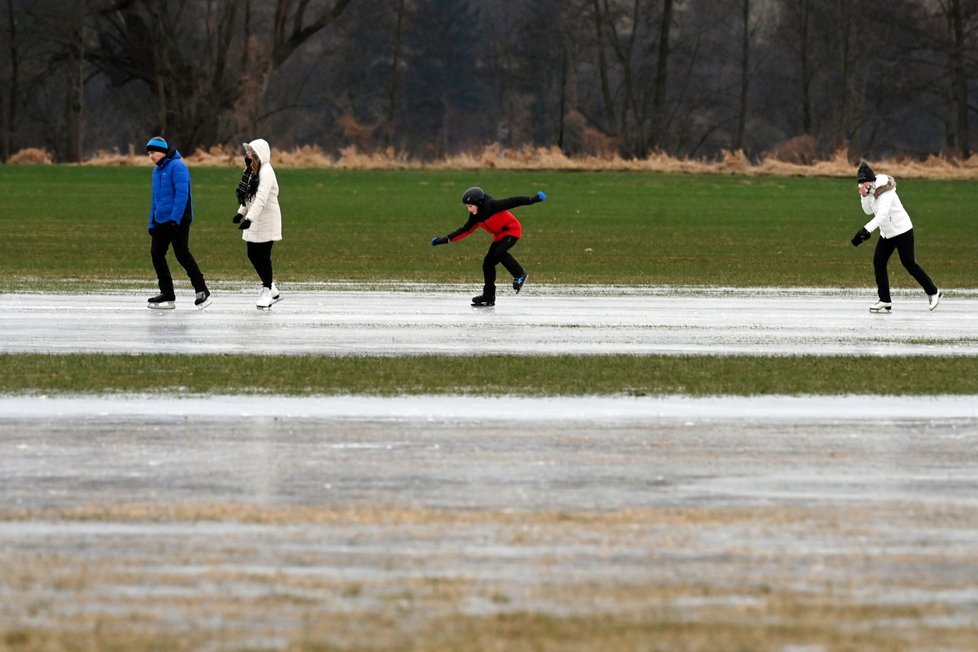 Stovky bruslařů využívají zamrzlou lagunu, kterou při nedávné velké vodě vytvořila Mže na lukách u Malesic nedaleko Plzně, 13. ledna 2024.