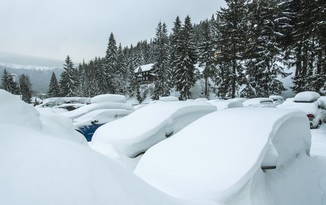 Automobily na parkovišti v Peci pod Sněžkou téměř zmizely pod přívaly sněhu.