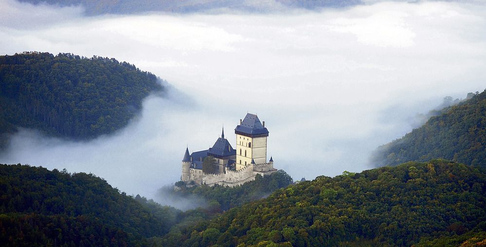 Hrad Karlštejn vystupuje z mlhy a brdských lesů. Mlhy nás budou provázet celý říjen.