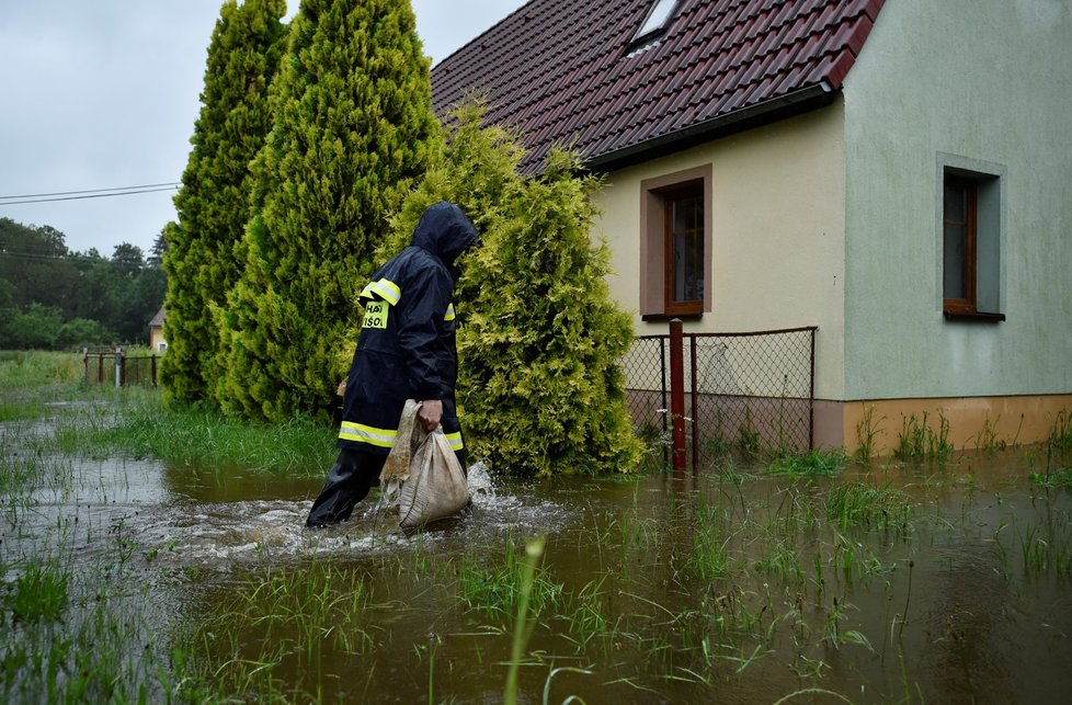 Hasič s pískem ve vesnici Předlánce, místní části obce Višňová.