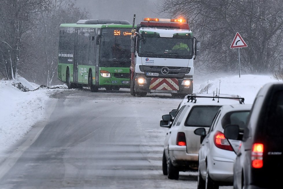 Husté sněžení ochromilo dopravu v Ústeckém kraji. Snímek ukazuje vyprošťování autobusu v Háji u Duchcova na Teplicku. (9.1.2019)