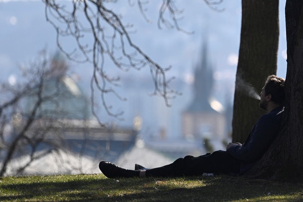 Muž si užívá slunného odpoledne na Letenské pláni v Praze (23. 3. 2022)