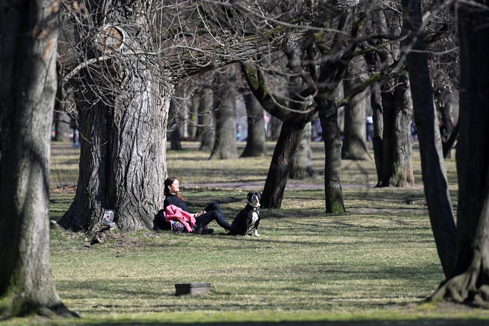 Žena si užívá slunného odpoledne na Letenské pláni v Praze (23. 3. 2022)