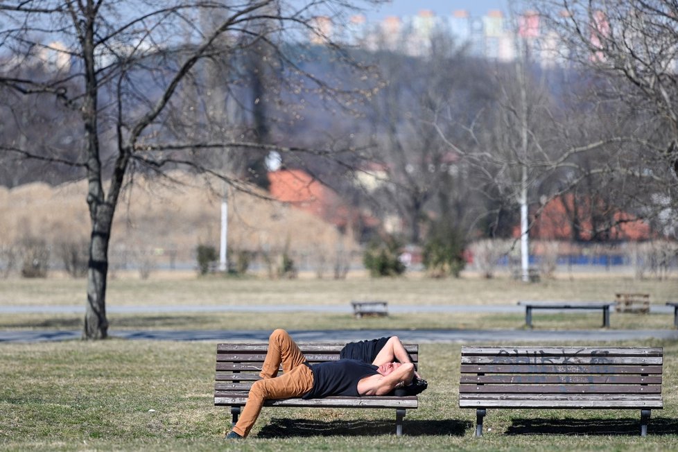 Muž si užívá slunného odpoledne na Letenské pláni v Praze (23. 3. 2022)