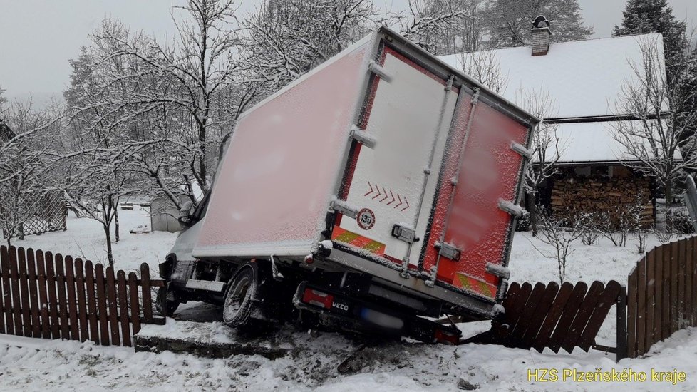 Nákladní vůz dostal na zasněžené silnici na Klatovsku smyk a skončil v plotu rodinného domu.
