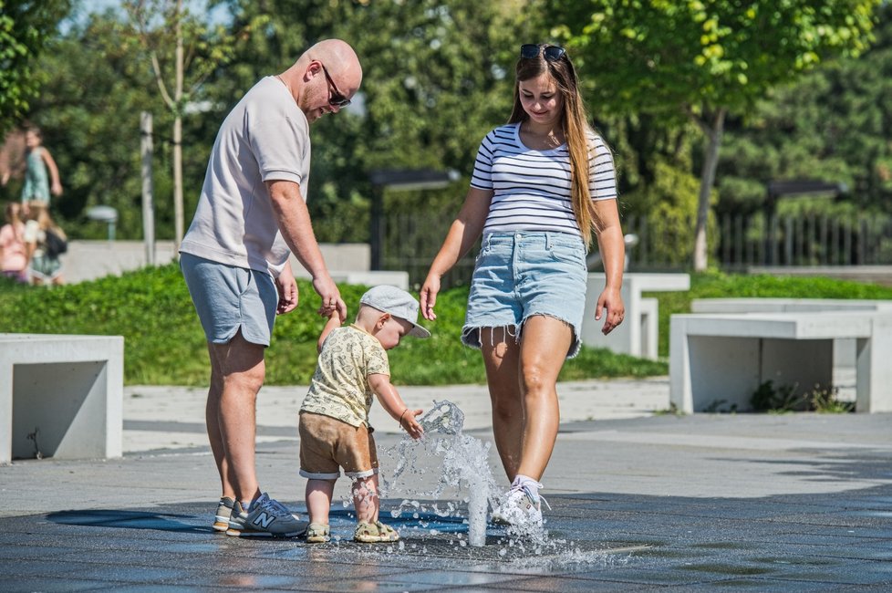Děti i dospělí se v horkém dni ochlazují u fontány na piazzettě před Janáčkovým divadlem v Brně