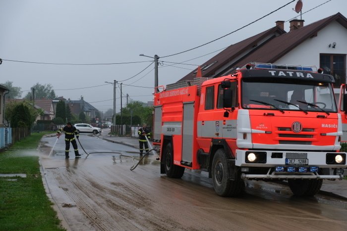 Hasiči odklízí po lijáky nánosy bahne v obci Hať v Moravskoslezském kraji.