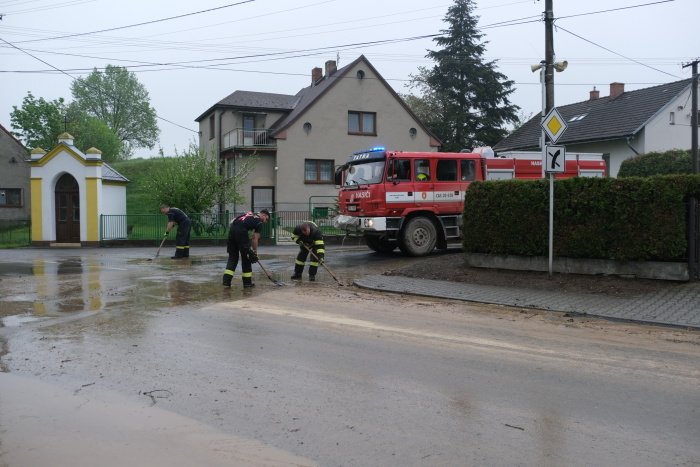 Hasiči odklízí po lijáku nánosy bahna v obci Vřesina v Moravskoslezském kraji.