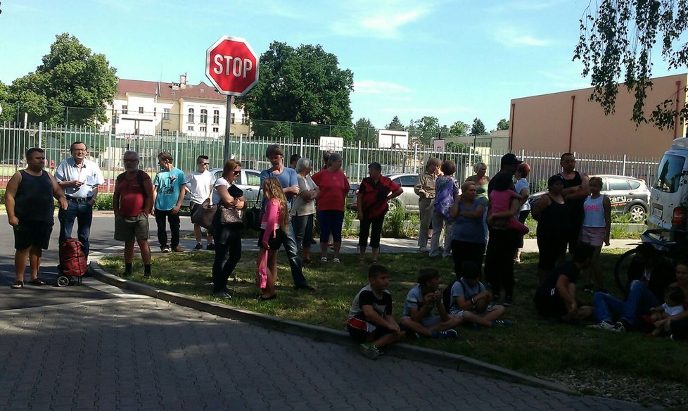 Evakuovaní lidé čekají před domem, zda se budou moci vrátit do svých bytů.