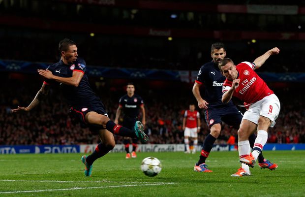 Lukas Podolski střílí druhou branku do sítě Olympiakosu Pireus Lukas Podolski střílí druhou branku do sítě Olympiakosu Pireus