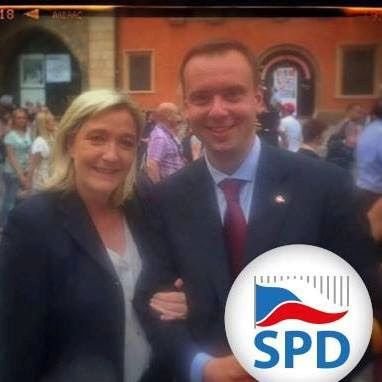 Na Facebooku se Alexandr Š. prezentuje jako Okamurův funkcionář, který organizoval návštěvu Marine Le Pen v Praze.