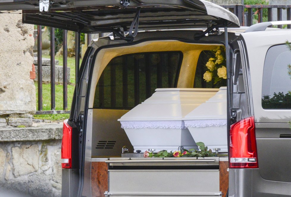 Dvojčata vezl pohřební vůz v bílých rakvích.