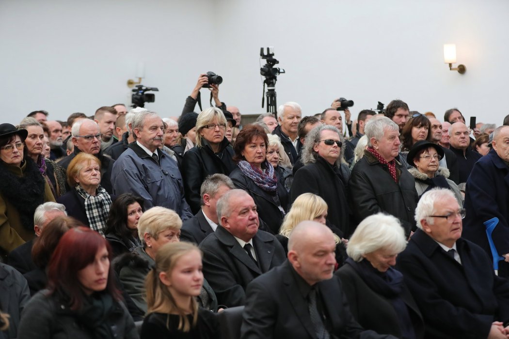 Smuteční síň je plná truchlících hostů.