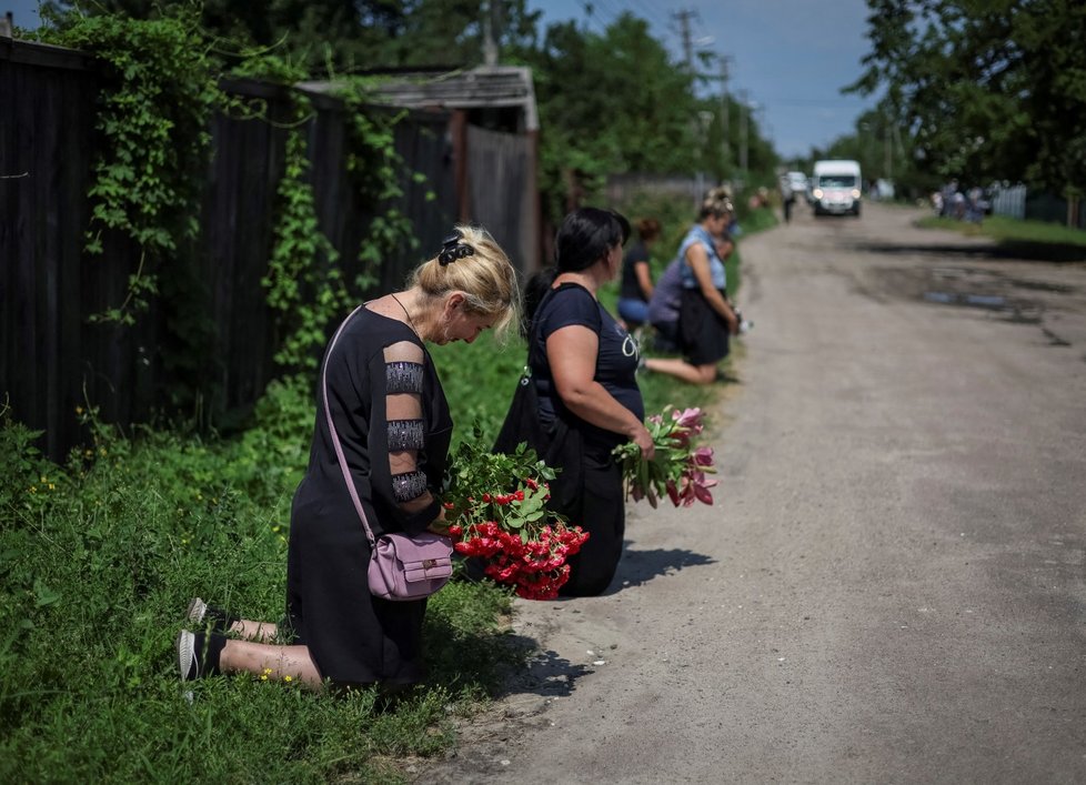 Lidé se klaní smutečnímu procesí.