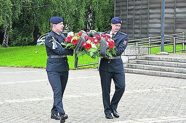 Dvojice mužů v uniformě přinesla smuteční věnec.