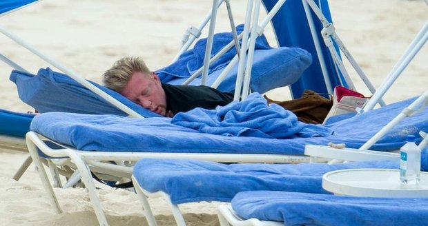 Unsul a spí... Boris Becker byl po náročném pokerovém turnaji tak unavený, že si musel lehnout. Jenže na pláži si spálil obličej.