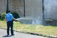 Hořící trávu poblíž služebny uhasili strážníci pomocí hadice