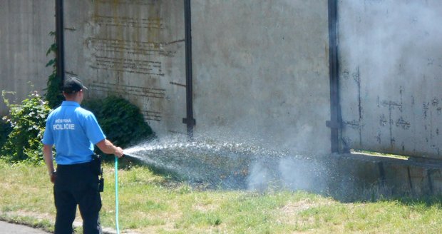 Hořící trávu poblíž služebny uhasili strážníci pomocí hadice