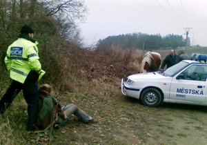 V dece zabalená pohřešovaná žena sedí na zemi chvíli po příjezdu strážníků.