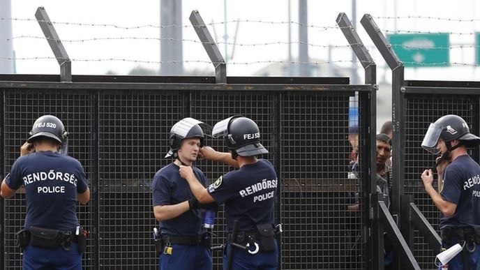 Maďarští policisté hlídkující u brány na hranici se Srbskem poblíž města Röszke. 