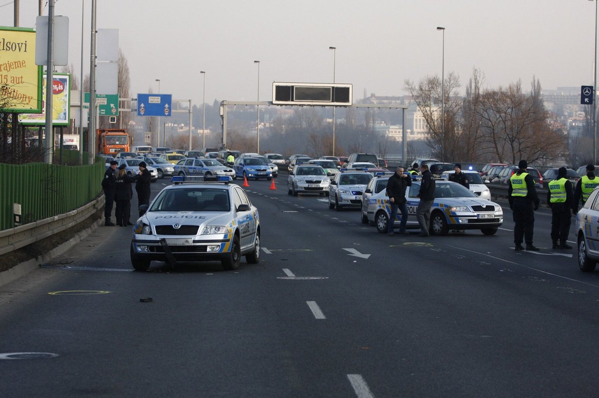 Nabourané policejní auto na místě střelby. Řidiči tu stáli v kolonách.