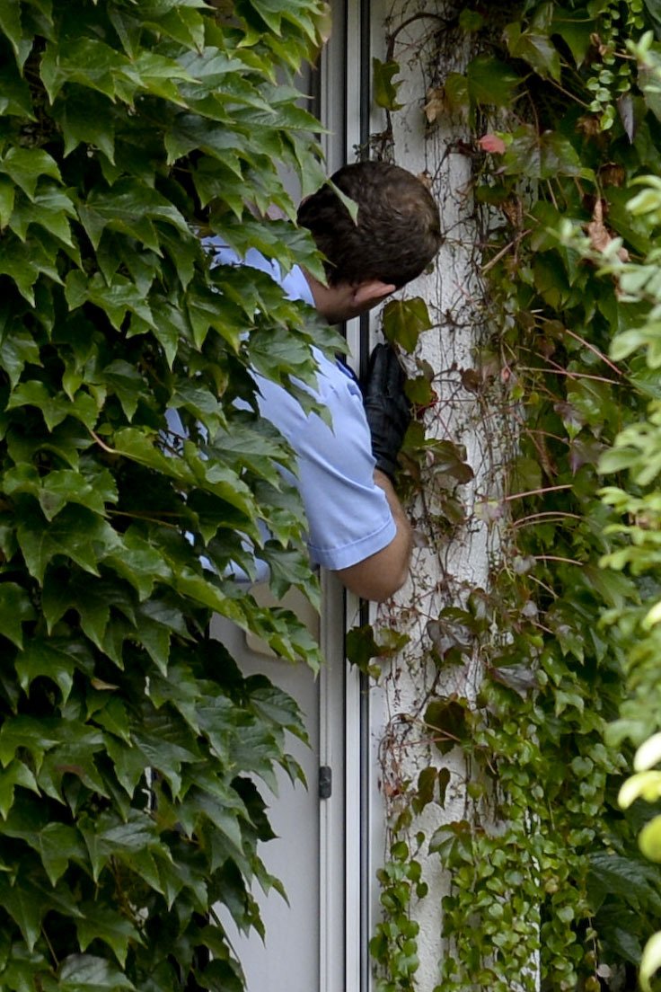 Policista kontroluje, zda nedošlo k násilnému vniknutí do domu.