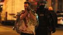 Policista vyvádí zraněného z koncertní síně Bataclan