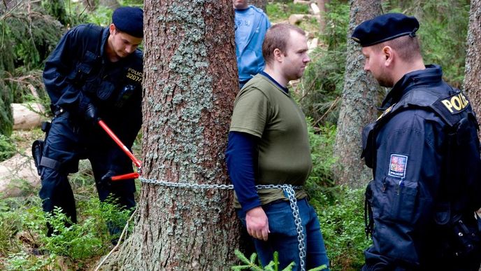 Policisté odstraňují řetěz, kterým se v šumavské lokalitě Na Ztraceném u Modravy připoutal loni jeden z ekologických aktivistů bránících kácení stromů v Národním parku Šumava.