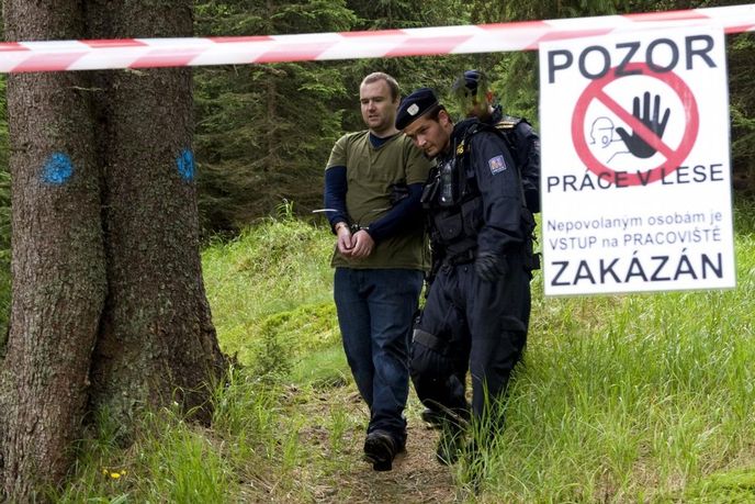 Policisté odvádějí ekologického aktivistu v šumavské lokalitě Na Ztraceném u Modravy, kde se lidé pokoušeli 26. července bránit kácení stromů napadených kůrovcem.