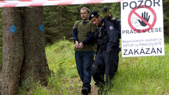 Policisté odvádějí ekologického aktivistu v šumavské lokalitě Na Ztraceném u Modravy, kde se lidé pokoušeli 26. července bránit kácení stromů napadených kůrovcem.