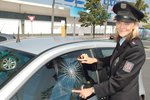 Policistka Martina Korandová lepí samolepku na sklo auta. Řidič si totiž nechal uvnitř vozu cenné věci.