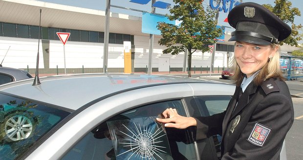 Policistka Martina Korandová lepí samolepku na sklo auta. Řidič si totiž nechal uvnitř vozu cenné věci.