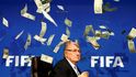 Britský komik známý jako Lee Nelson (není na snímku) hází bankovky prezidentovi FIFA Seppu Blatterovi na tiskové konferenci po mimořádném zasedání výkonného výboru FIFA v sídle organizace v Curychu, Švýcarsko, 20. července 2015.