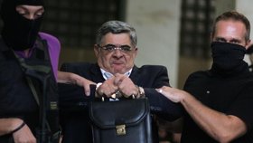 Řecký politik Nikos Michaloliakos se netváří zrovna dvakrát šťastně. Bodejť by jo, když ho vedou do policejní cely.