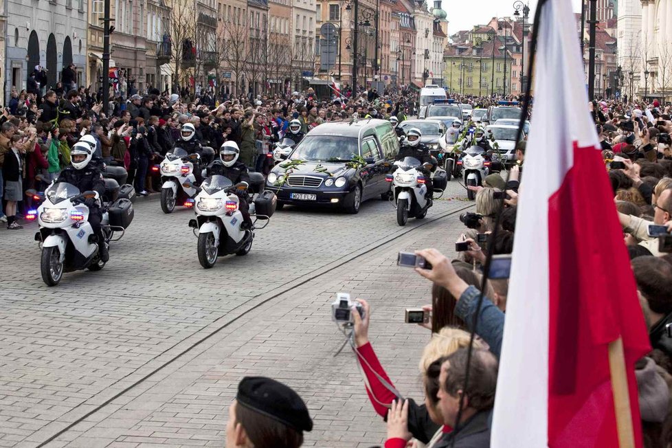 Kolona s pohřebním vozem projíždí Varšavou