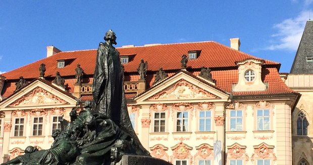 Mistr Jan Hus na pomníku hledí na nedaleký chrám.