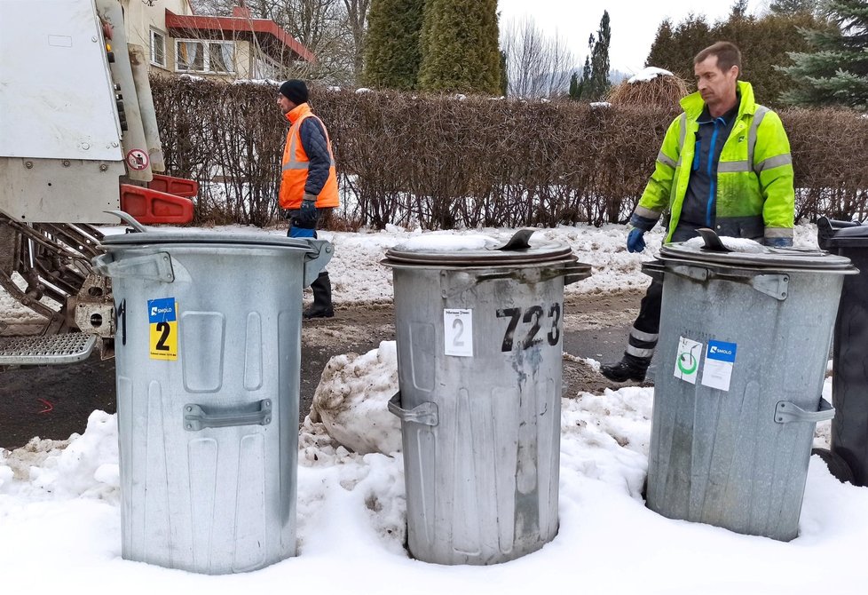 Pomocníci Roman se Zdeňkem dolují těžké popelnice ze sněhu. Denně jich vysypou až 450.