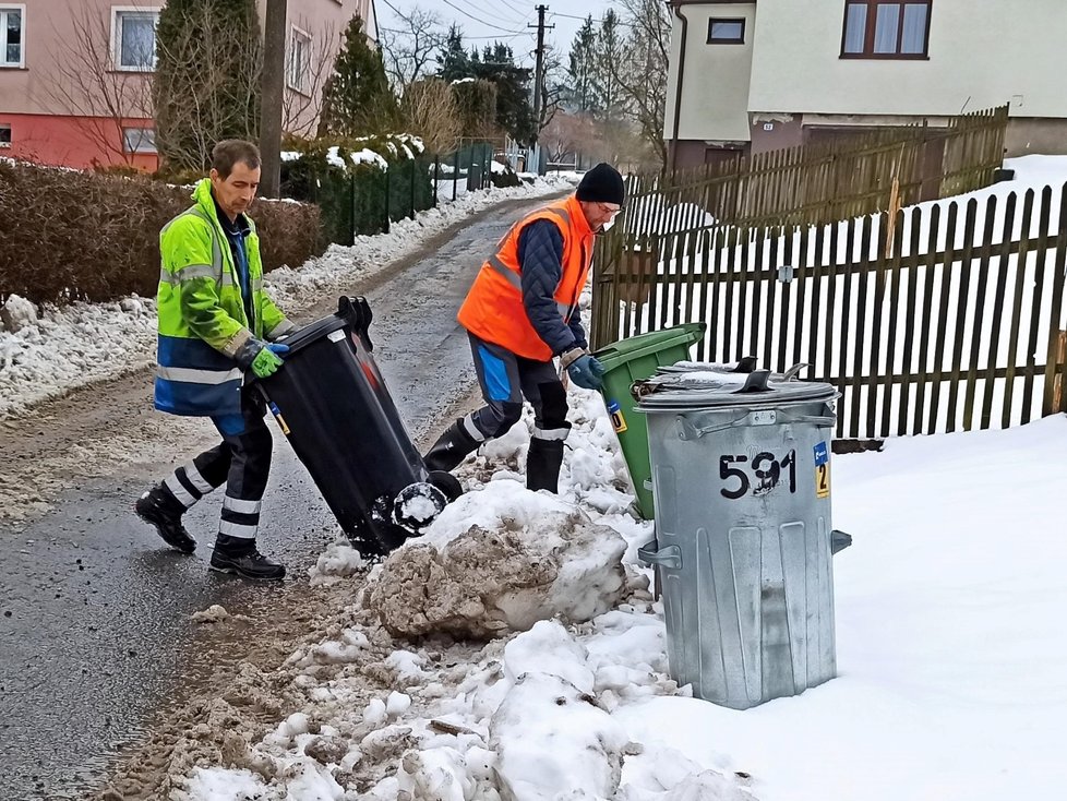 Pomocníci Roman se Zdeňkem dolují těžké popelnice ze sněhu. Denně jich vysypou až 450.