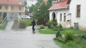 Lidé v Benešově nad Černou stavěli před domy rozvodněné říčce do cesty pytle s pískem.