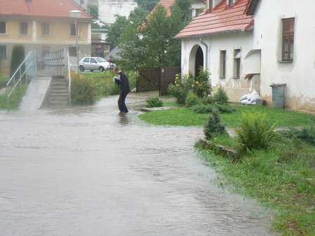 Lidé v Benešově nad Černou stavěli před domy rozvodněné říčce do cesty pytle s pískem.