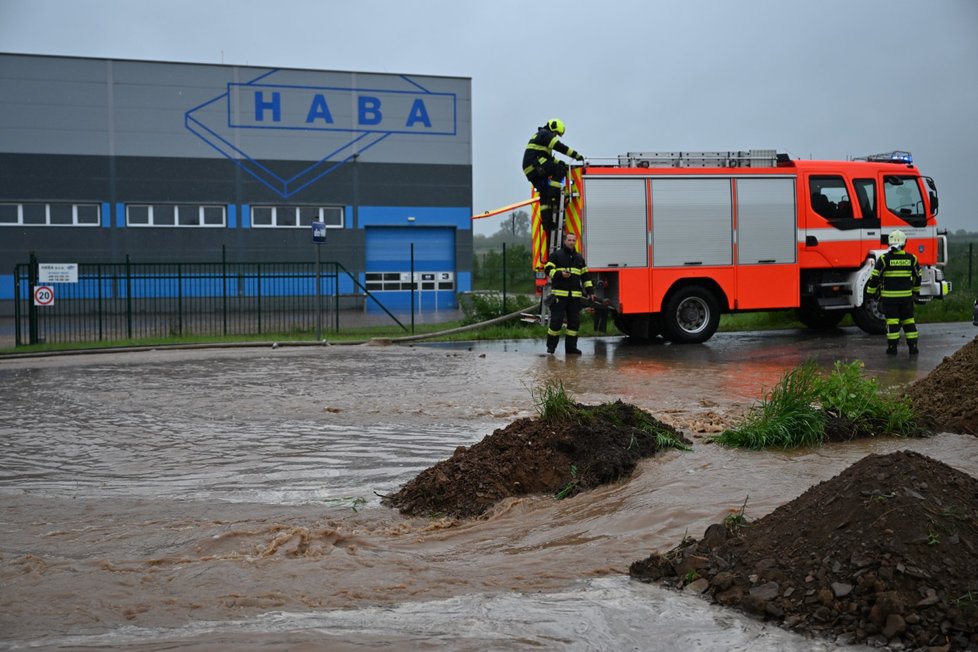 Rozlitá voda u výrobní haly v Sudoměřicích, kde se hasiči snaží budovat provizorní hráze proti vodě vylité z Radějovky a Sudoměřického potoka.