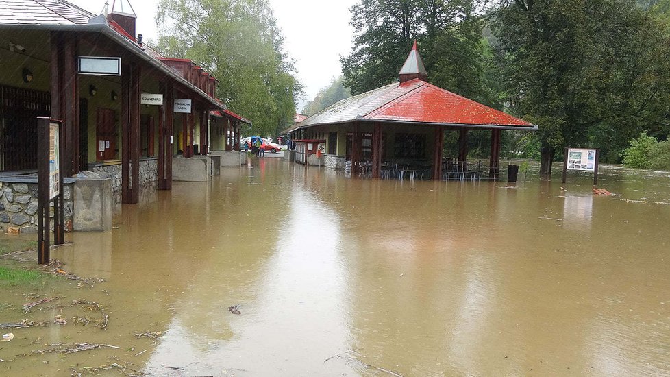 Takhle to vypadalo ve středu před vstupem do areálu Sloupsko-šošůvských jeskyní v Moravském krasu.  Rozvodněný Sloupský potok proměnil parkoviště a odpočinkovou zónu v jednu obří lagunu.