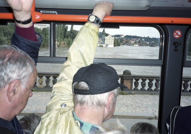 Cestující z tramvaje pozorují rostoucí hladinu Vltavy roku 2002.