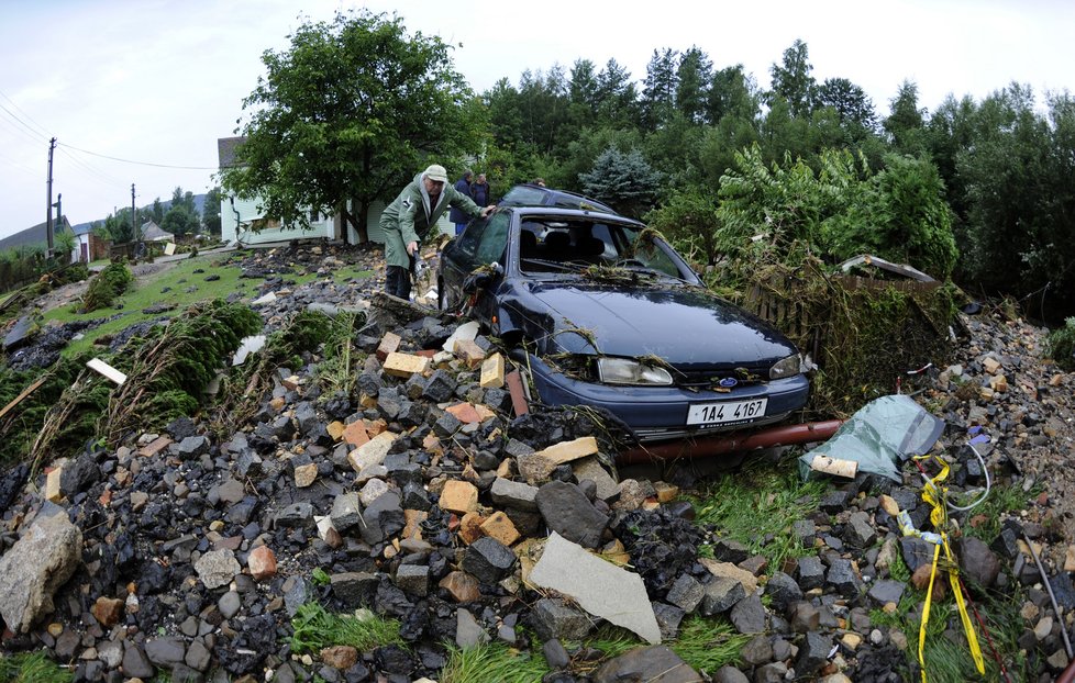 Majite prohlíží zničené auto, které mu vzala voda