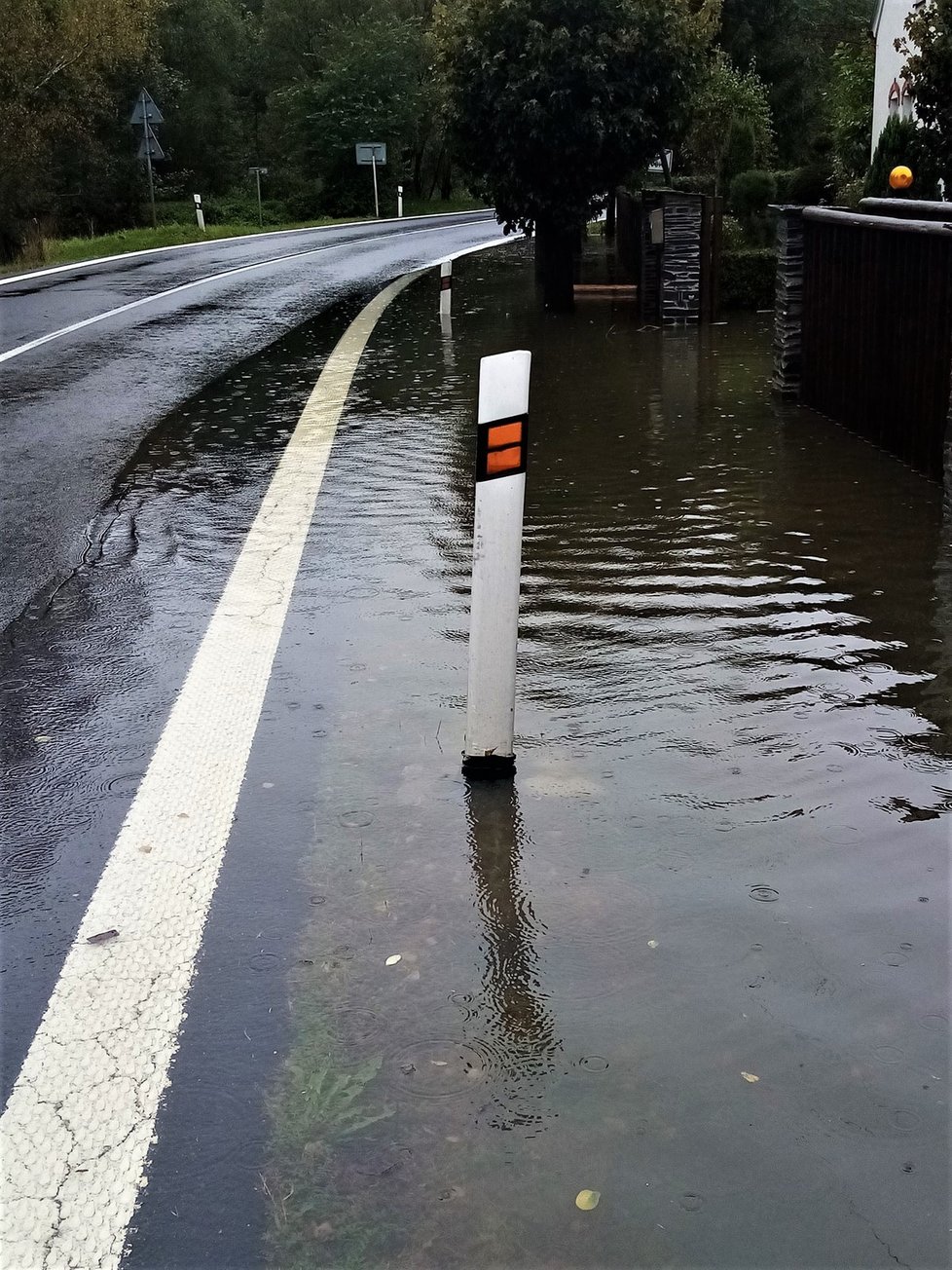 Voda se rozlila po silnici v Loučce u Zátoru v Moravskoslezském kraji. (14.10.2020)