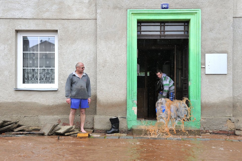 Hostinné na Trutnovsku zaplavilo 2. června rozvodněné Labe. V centru bylo zhruba 40 centimetrů vody, se záchranou odříznutých lidí pomáhal vrtulník. Jaroslav a Jan Jakubcovi (zleva) uklízejí vyplavený dům.