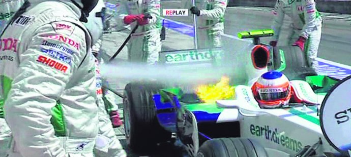 Mechanici v boxes hasí požár na monopostu Rubense Barrichella